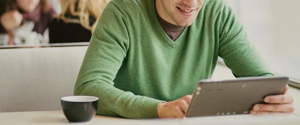 Man viewing tablet in cafe