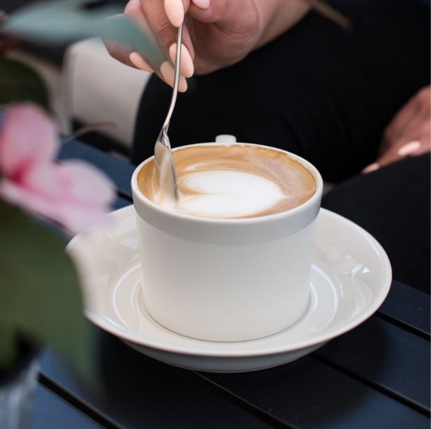 Zbliżenie na filiżankę kawy na drewnianym stole