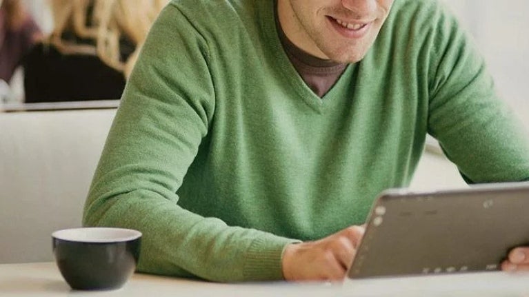 Man viewing tablet in cafe