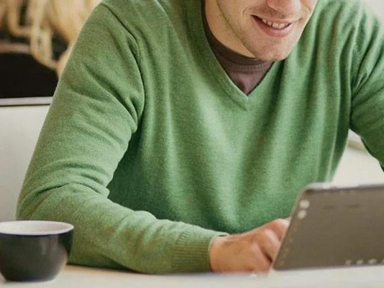 Man viewing tablet in cafe