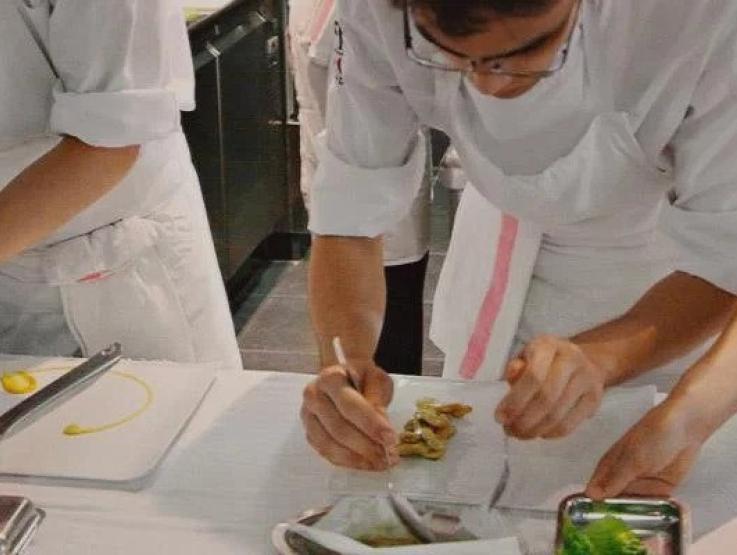 Line of cooks working in a professional kitchen