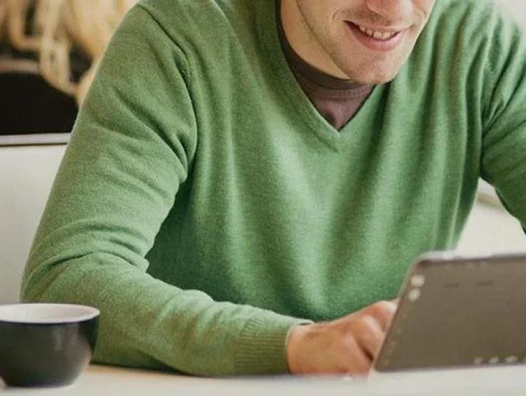 Man viewing tablet in cafe