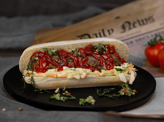 Hot-dog z grillowaną wegańską kiełbaską, sałatką coleslaw i salsą ogórkową
