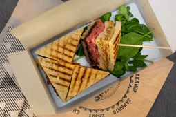 Kanapka klubowa z wołowiną pieczoną, wędzonym boczkiem, serem ementaler i konfiturą z czerwonej cebuli